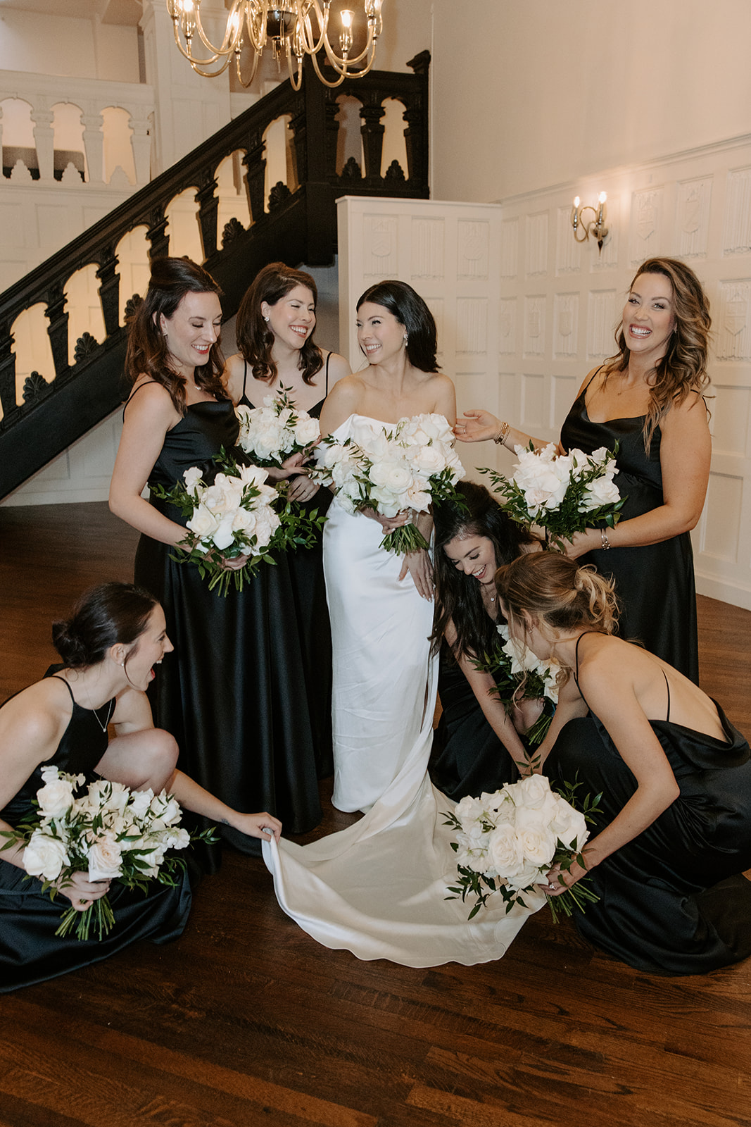 Bridal party posing with bride with bouquet of white flowers at Alden Castle.